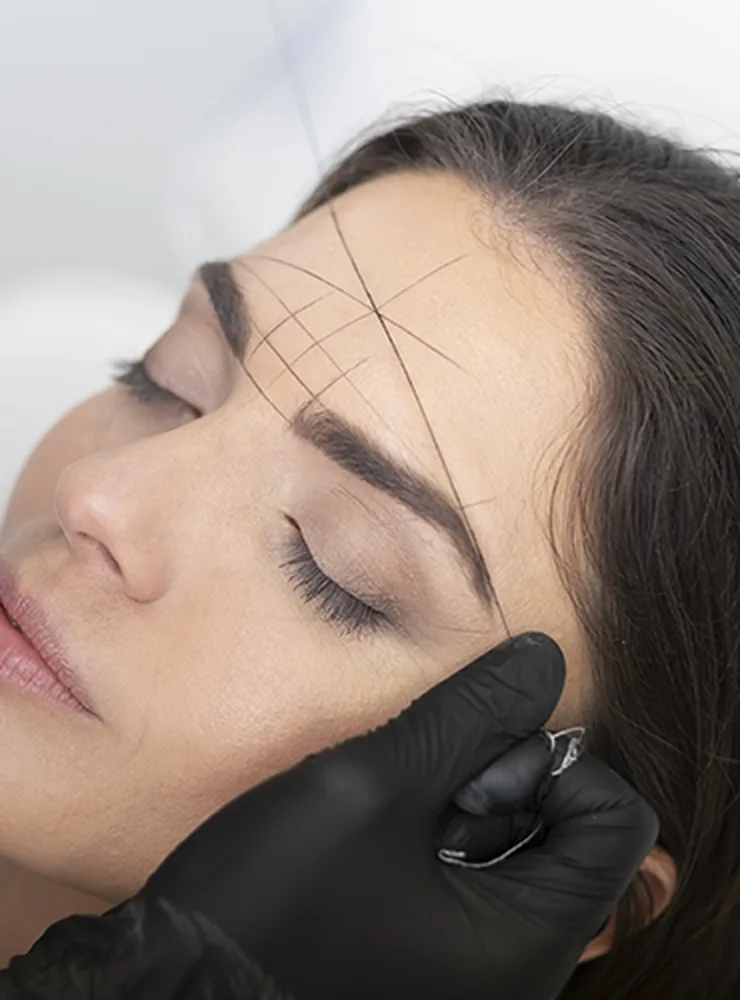 Brow mapping being drawn onto a client’s brow before shaping