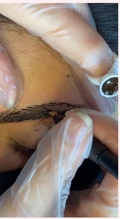 Microblading strokes being applied to a brow